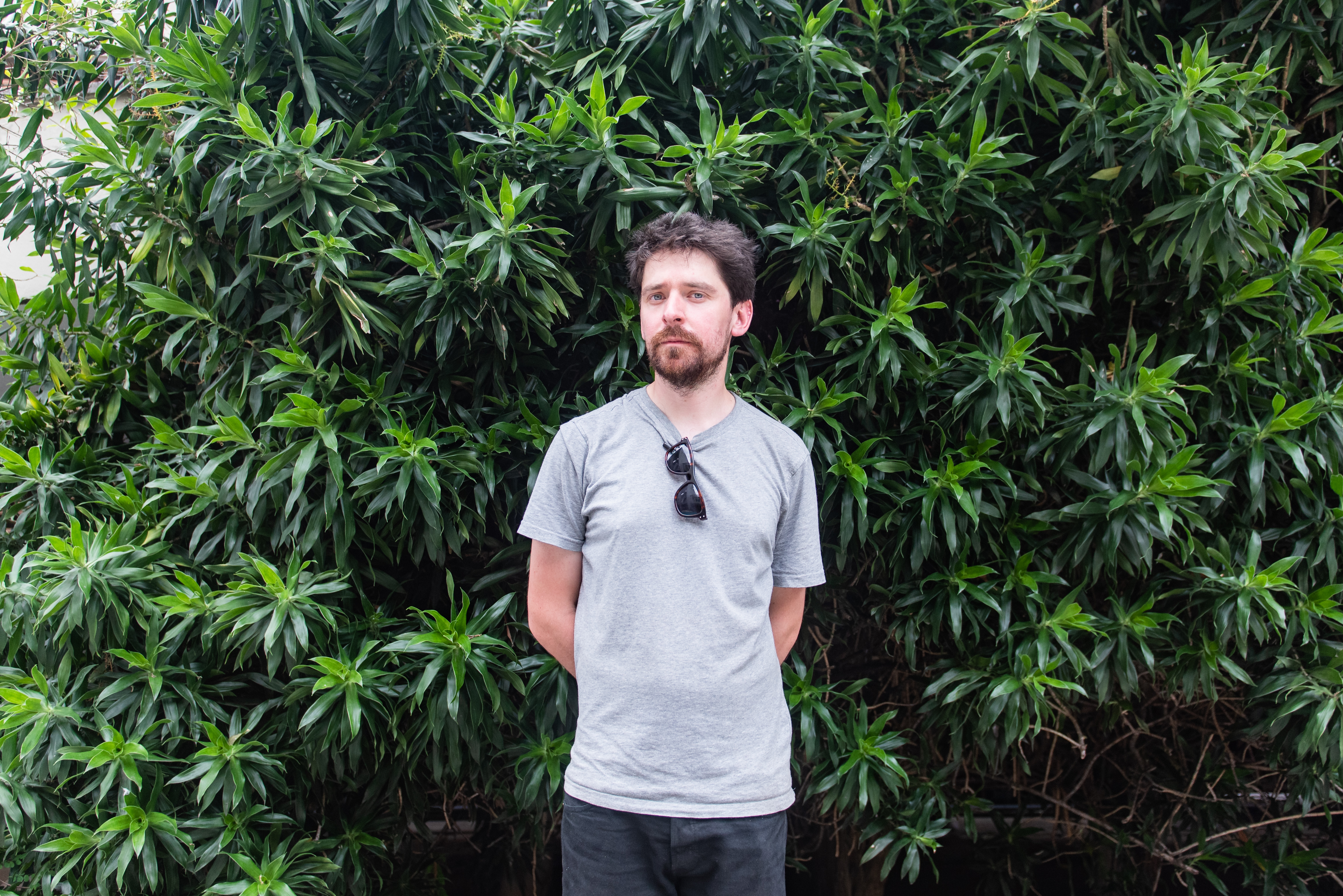 man, Tim Shaw, stands in front of green background in Brazil