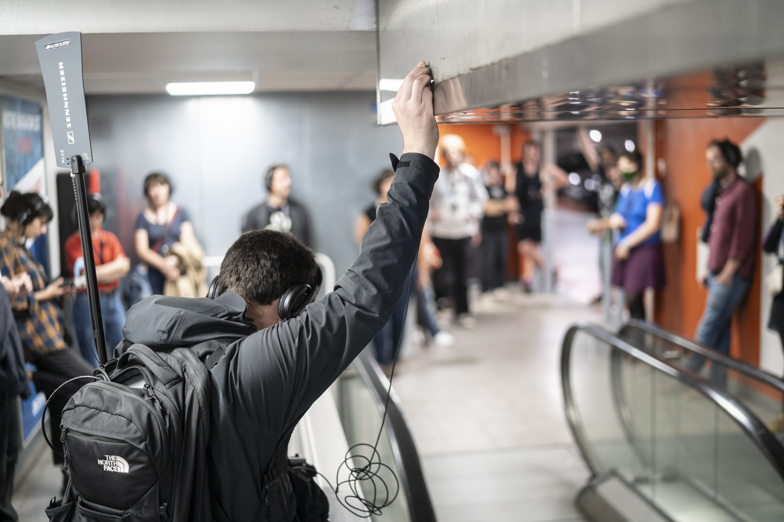 Ambulation holding contact mic on escalator